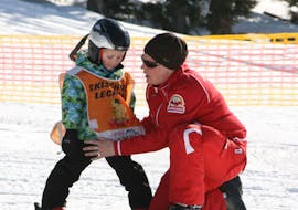 Een skileraar van de skischool Skischule Lechner in Zell am Ziller begeleidt een jong kind tijdens de privé skilessen voor kinderen voor alle leeftijden.