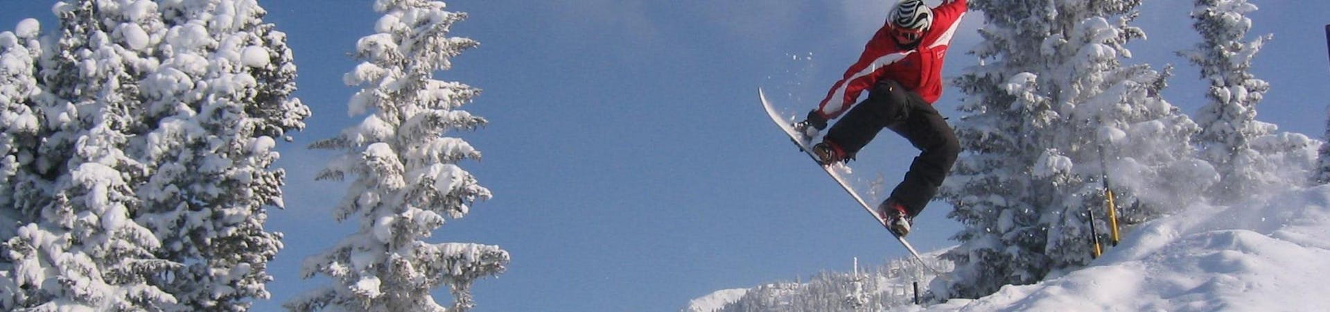 Ein Snowboarder macht bei seinem Snowboardkurs für Erwachsene - Anfänger mit der Skischule Lechner in Zell am Ziller beeindruckende Freestyle Tricks.