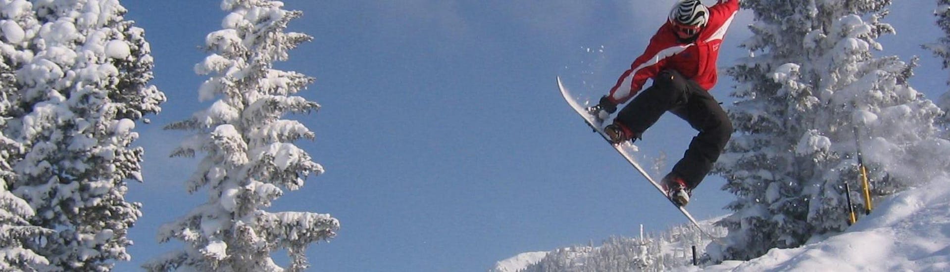 Een snowboarder laat een paar indrukwekkende trucs zien tijdens hun snowboardlessen voor volwassenen voor beginners bij de skischool Skischule Lechner in Zell am Ziller.