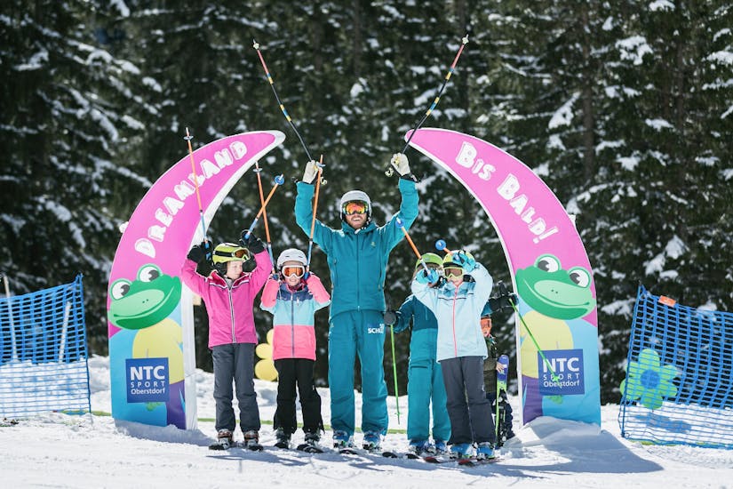 Kleine Skibegeisterte machen ihre ersten Schritte auf Skiern im Schnupper Kinder Skikurs "Dreamland" (4-6 Jahre) - Anfänger unter der Aufsicht des Skilehrers der Skischule NTC Skischule Oberstdorf.