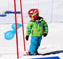 Een kind geniet van de eerste stappen op de ski's tijdens de Trial Kids Ski Lessons "Dreamland" (4-6 jaar) - Beginners met een instructeur van de skischool NTC Skischule Oberstdorf.