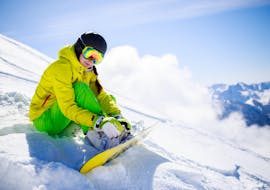 Un snowboarder assis sur la piste lors des leçons privées de snowboard pour enfants et adultes de tous niveaux de l'Active Snow Team Engelberg.