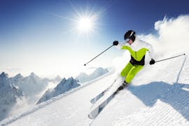 Een skiër rijdt op een zonnige dag de helling af tijdens de privélessen skiën voor volwassenen van alle niveaus van Active Snow Team Engelberg.