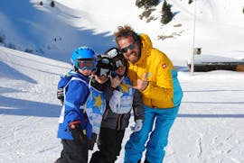 Trois enfants sont heureux d'avoir passé un cours particulier de ski avec un moniteur de la Villars Ski School.