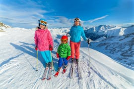 Une famille de trois personnes profitant des leçons de ski privées pour les familles de l'Active Snow Team Engelberg.