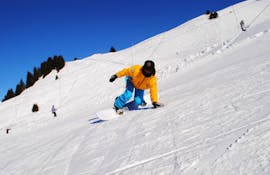 Een instructeur van de Villars Skischool laat tijdens een privé snowboardles zien hoe je een bocht maakt en je evenwicht bewaart.