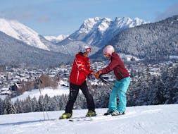 A ski instructor from the Sport Aktiv Seefeld ski school shows a student the correct body posture during ski lessons for adults of all levels.