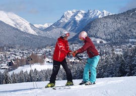 A ski instructor from the Sport Aktiv Seefeld ski school shows a student the correct body posture during ski lessons for adults of all levels.