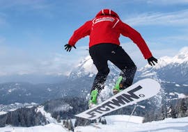 Un moniteur de snowboard de l'école de ski Sport Aktiv Seefeld pendant un saut dans le parc.