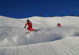 Een skiër geniet van de verse sneeuw tijdens privé skilessen voor volwassenen van alle niveaus bij Skischule Waidring Steinplatte.