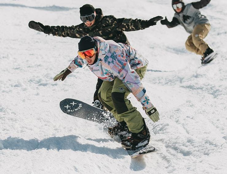 Snowboardkurs (ab 13 J.) für fortgeschrittene Snowboarder in Planai & Hochwurzen mit Snowboardschule Boardstars Schladming Drei Snowboarder shredden durch den Schnee beim Snowboardkurs für Fortgeschrittene mit Boardstars Schladming.