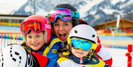 A instructor and her pupils during the Kids Ski Lessons "Mini-Yappy" (3-4 y.) for Beginners with the Snow Sports School Eichenhof St. Johann.