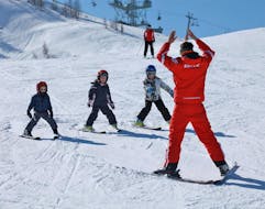 A group of kids and their instructor during the Kids Ski Lessons (4-11 y.) for Beginners with the HERBST Ski School Lofer.
