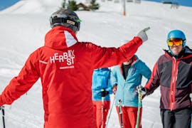 Un moniteur enseignant pendant les Cours de ski Adultes (dès 16 ans) pour Débutants avec l'école de ski HERBST Ski School Lofer.