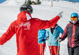 Un moniteur enseignant pendant les Cours de ski Adultes (dès 16 ans) pour Débutants avec l'école de ski HERBST Ski School Lofer.