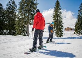 Un homme suivant son moniteur pendant les Cours particulier de Snowboard pour Tous niveaux et Tous âges avec l'école de ski HERBST Ski School Lofer.