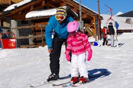 Una joven esquiadora está aprendiendo a esquiar con el apoyo de su instructor de esquí de la escuela Snocool en Tignes, durante sus clases particulares de esquí para niños de todas las edades.