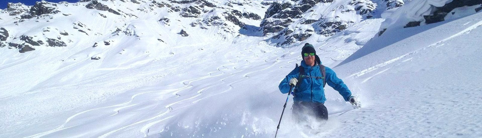 Un freerider disfruta de la nieve fresca en polvo durante sus clases particulares de esquí fuera de pista para adultos - Avanzado, con la escuela de esquí Snocool Tignes.