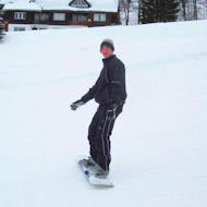 A man is learning the correct snowboarding technique during the snowboarding lessons for kids & adults - Beginners in the Schneesportschule Black Forest Magic Feldberg.