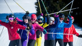 Eine Gruppe Kinder jubelt beim Privaten Kinder-Skikurs (ab 5 J.) für alle Levels mit Lovell Ski Camps Gstaad-Saanen.