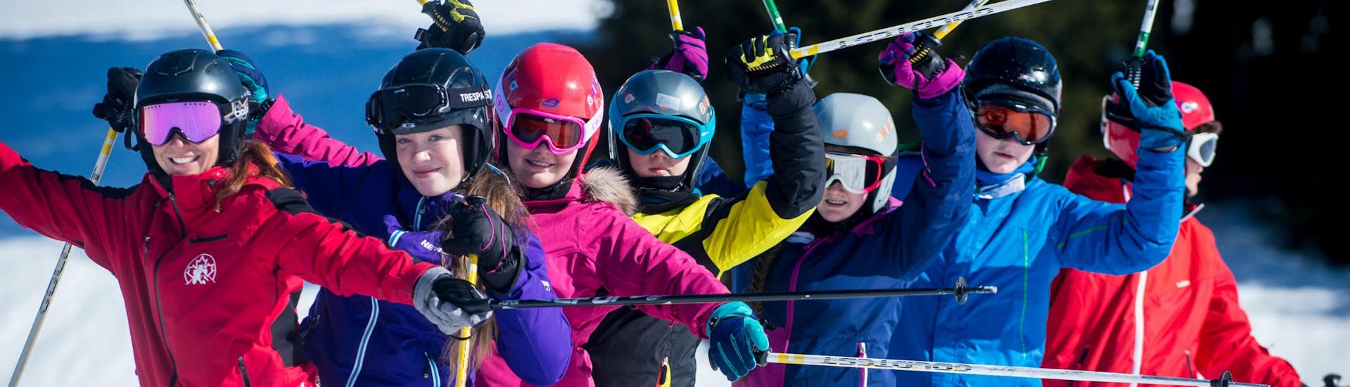 Een groep kinderen juicht tijdens hun privéles skiën voor kinderen (vanaf 5 jaar) van alle niveaus bij Lovell Ski Camps Gstaad-Saanen.