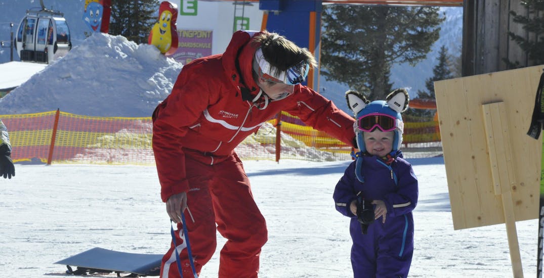 Een privéleraar met een kleine skiër tijdens de, privé skilessen voor kinderen van alle niveaus bij de skischool Kreischberg - Mayer.