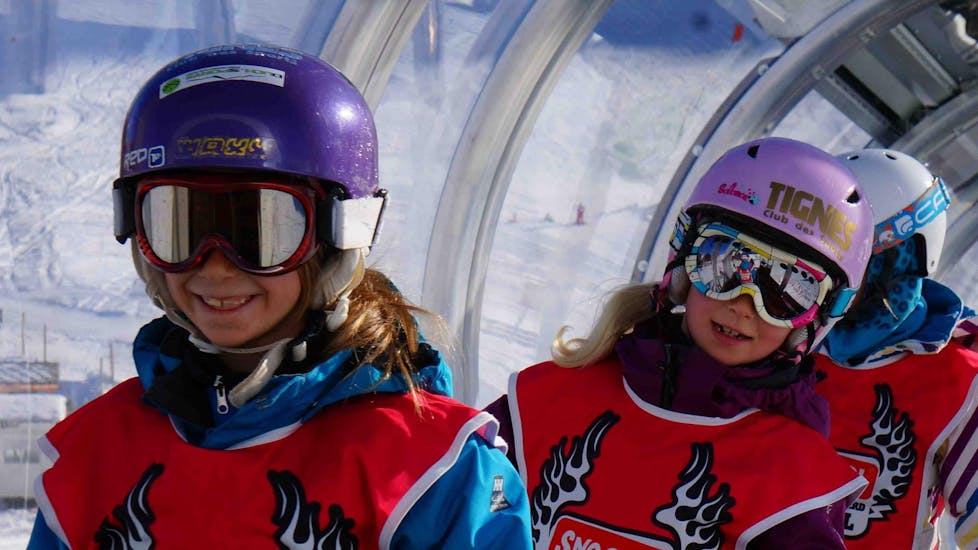 Two young children are enjoying their first session of Private Snowboarding Lessons - All Levels & Ages in the ski resort Val d'Isère.