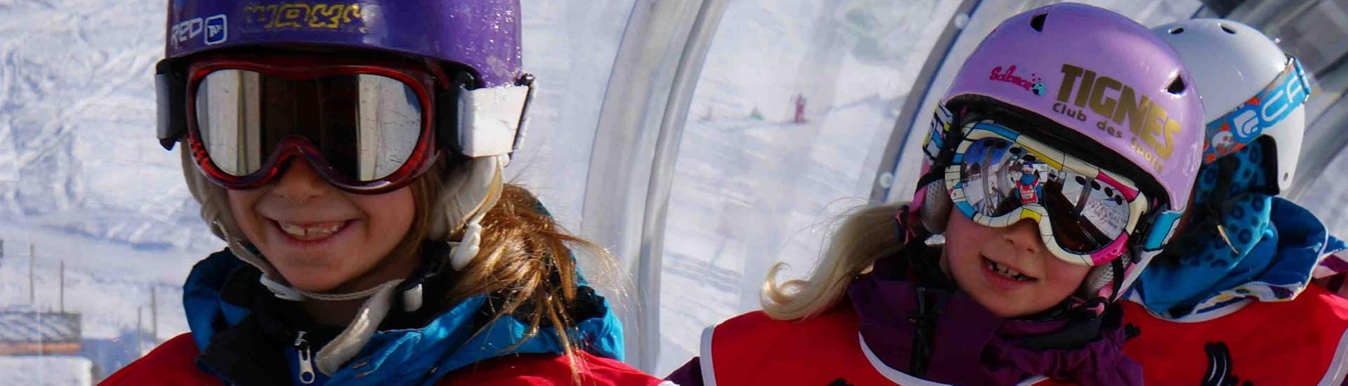 Deux jeunes enfants profitent de leur première session de Cours particulier de snowboard - Tous niveaux & âges avec l'école de ski Snocool dans la station de Val d'Isère.