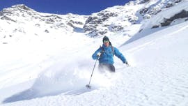 Onder begeleiding van een instructeur van de skischool SnoCool geniet een skiër van de verse poedersneeuw tijdens de Privé Off-Piste Skilessen voor Volwassenen - Val d'Isère.