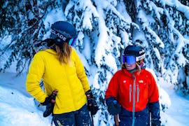 Twee skiërs lachen naar elkaar tijdens hun privélessen skiën voor volwassenen van alle niveaus bij Lovell Ski Camps Gstaad-Saanen.