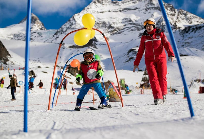 A child is having fun at their Kids Ski Lessons "Snow Fleas" (3-5 y.) for Beginners from Swiss Ski School Saas-Grund.
