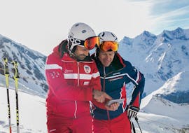 An instructor and an adult stand on the mountain at Adult Ski Lessons (from 13 y.) for All Levels from Swiss Ski School Saas-Grund.
