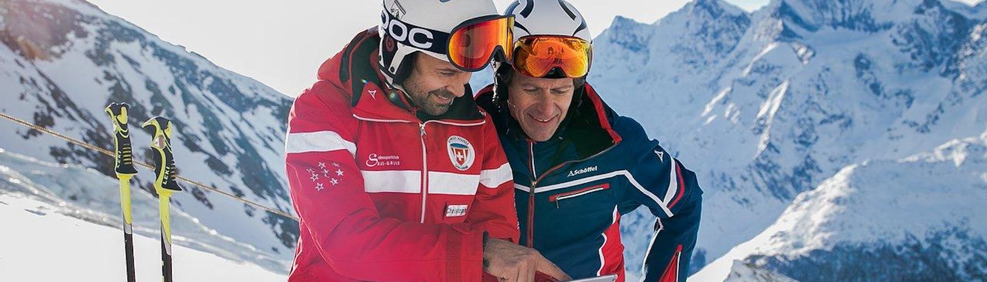 Ein Erwachsener und der Skilehrer stehen auf einem Berg beim Skikurs für Erwachsene (ab 13 J.) aller Levels mit Schweizer Skischule Saas-Grund.