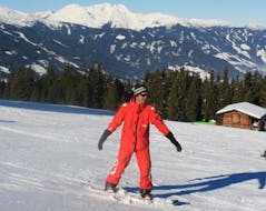 Ein Snowboardlehrer der Skischule Lechner in Zell am Ziller zeigt bei der Aktivität Privater Snowboardkurs - Alle Levels & Altersgruppen wie man richtig die Piste hinunter fährt.