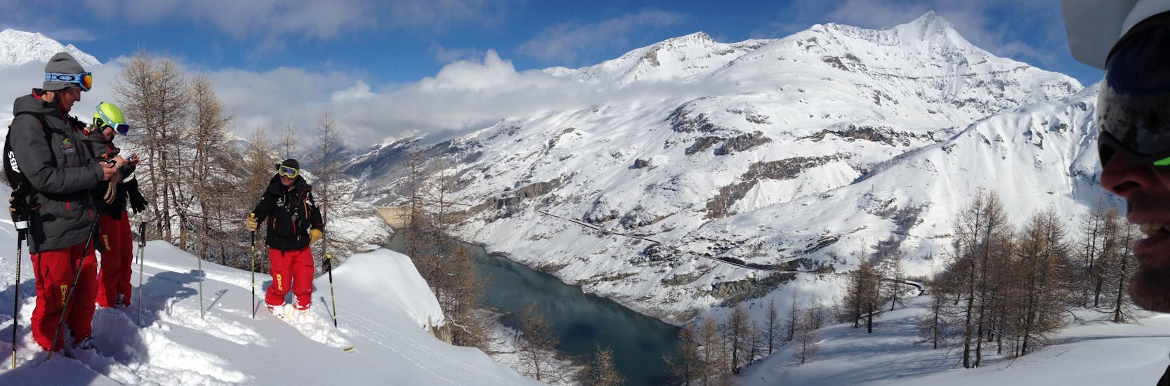 Skiers are overlooking the Tignes Lake during their Off-Piste Skiing Lessons with the ski school Evolution 2 Tignes.