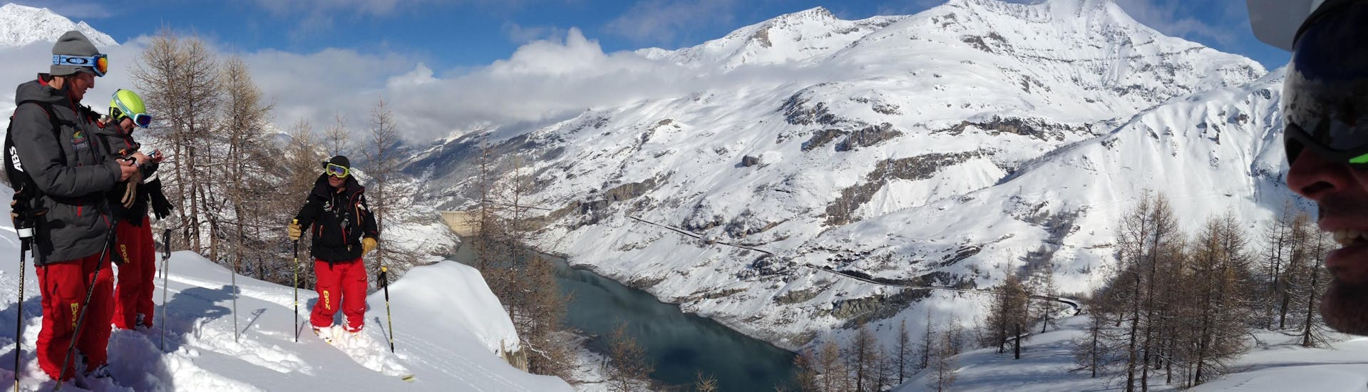 Skiers are overlooking the Tignes Lake during their Off-Piste Skiing Lessons with the ski school Evolution 2 Tignes.