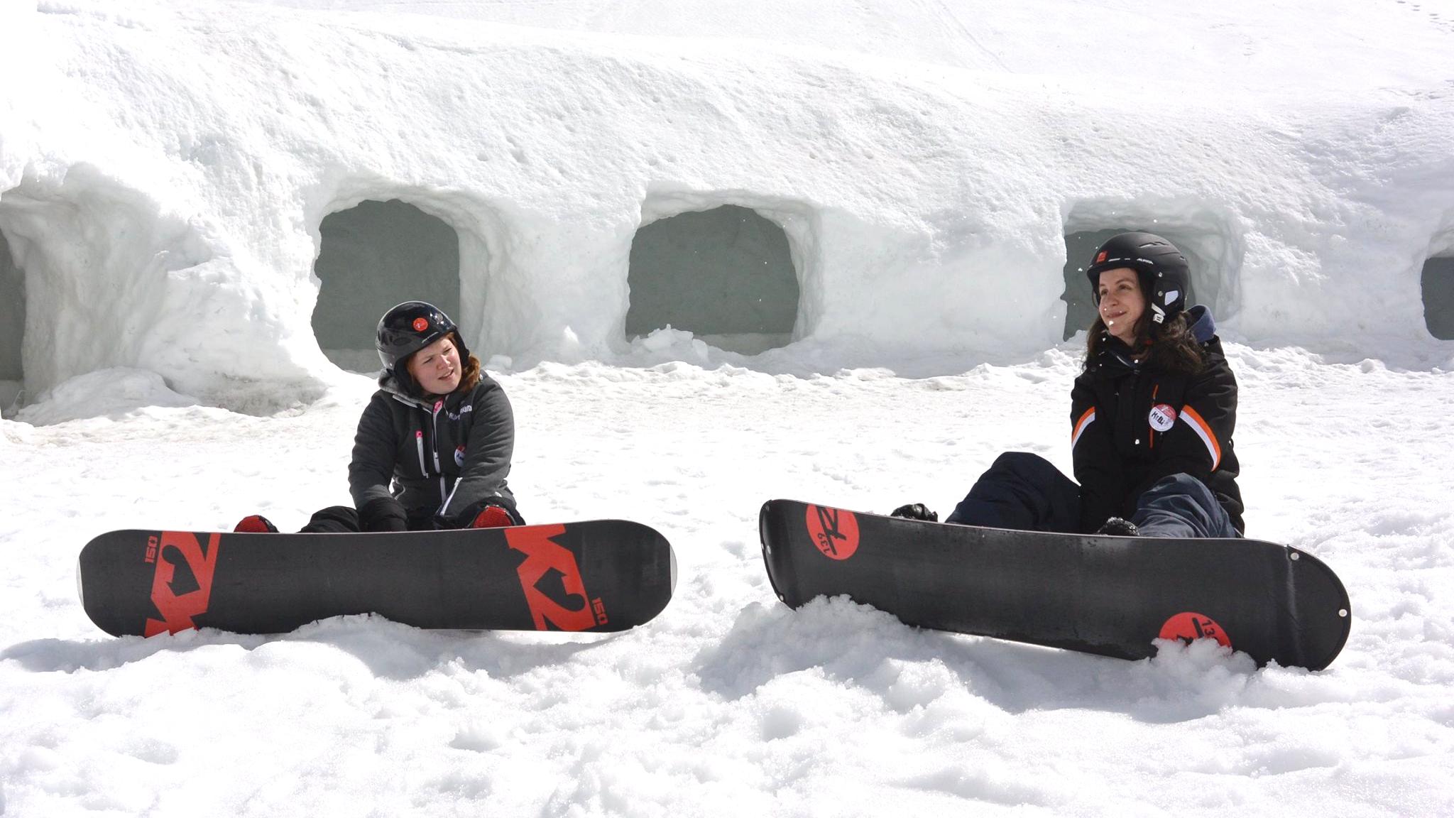 Two happy snowboarders are having break during the Snowboarding Lessons for Kids & Adults - All Levels organised by the ski school Neue Skischule Oberstdorf.