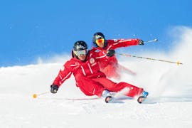 Twee instructeurs van de Zwitserse skischool in Crans-Montana demonstreren het carven tijdens privé-skilessen voor volwassenen.