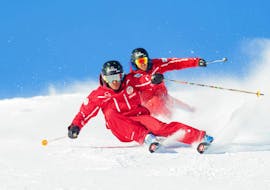 Twee instructeurs van de Zwitserse skischool in Crans-Montana demonstreren het carven tijdens privé-skilessen voor volwassenen.