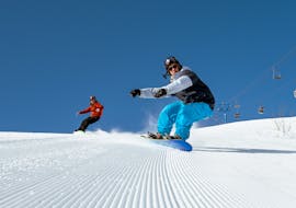 Picture of a guy snowboarding with an instructor from Skischule Total - Ehrwald.