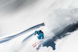 Uno sciatore scende magistralmente un couloir durante una lezione privata di sci freeride a Serre-Chevalier con ESI generation.