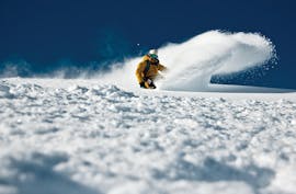 An experienced skier is going through pristine powder during a freeriding lesson in Serre-Chevalier with ESI generation.