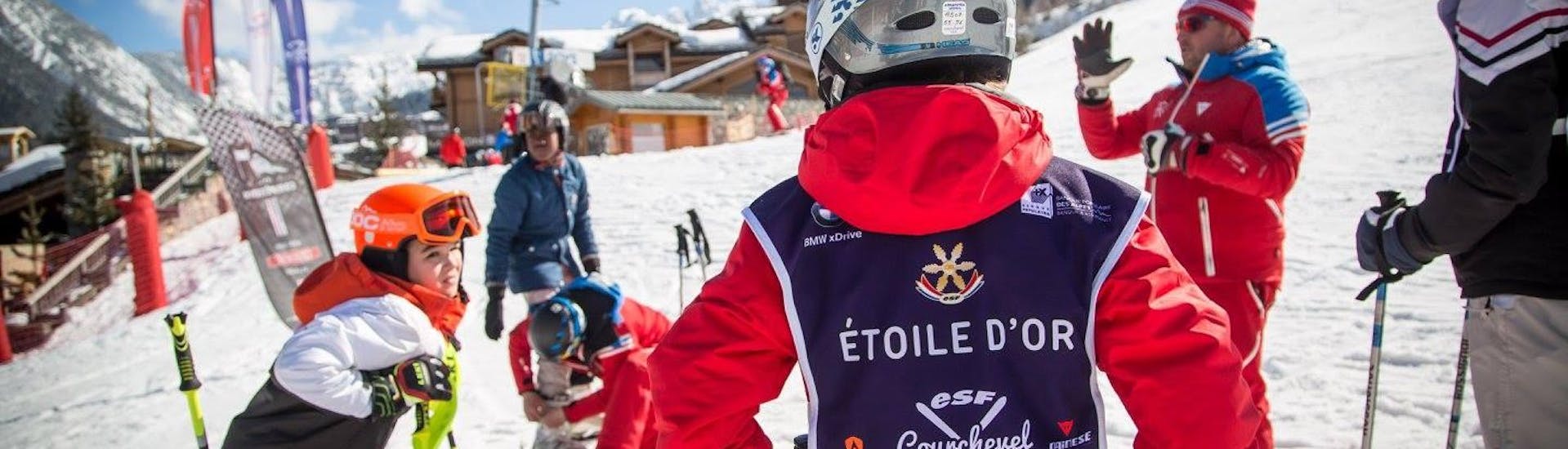 A group of young skiers warming up before their "Etoile d'Or" kids ski lesson with the ESF Courchevel Village. 