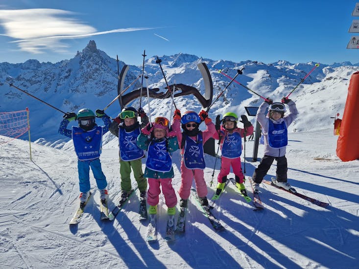 Un groupe de jeunes skieurs s'échauffent avant leur cours de ski pour enfants "Etoile d'Or" avec l'ESF Courchevel Village.