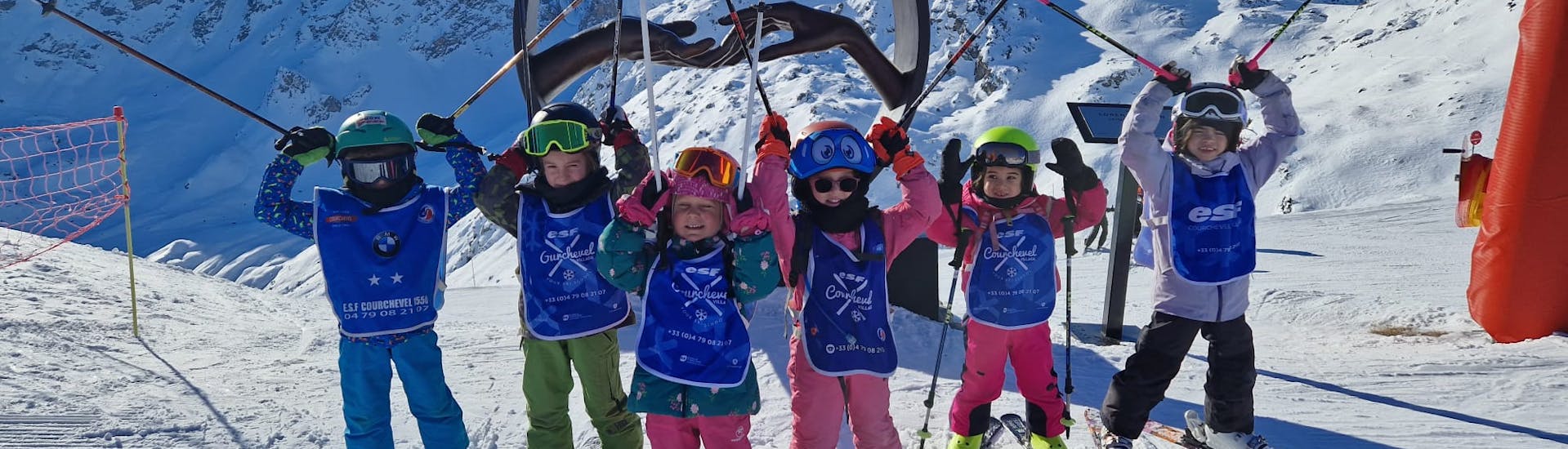 Een groep jonge skiërs warmen zich op voor hun "Etoile d'Or"-skiles voor kinderen met het ESF Courchevel Village.