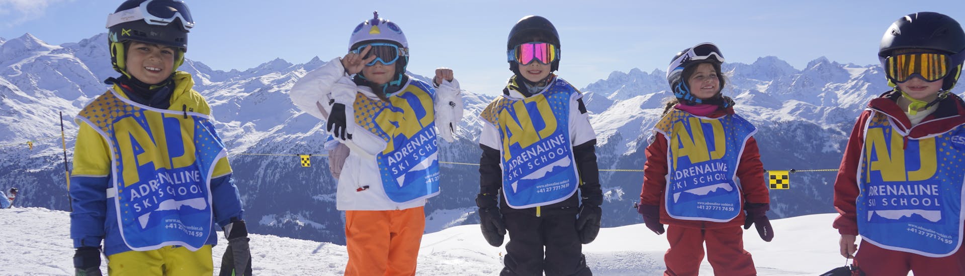 A group of 6 children learn to ski during kids ski lessons with Adrenaline Verbier.