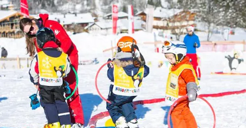 Skilessen voor kinderen (3-4 jaar) "Bambini" met Ski School Jochberg Drie kinderen spelen tijdens de skilessen voor kinderen "bambini" (3-4 j.) bij skischool Jochberg in Jochberg.