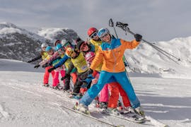 A row of children and their instructor in the snow during their kids ski lessons for all levels with Skischule Thommi in Nassfeld.