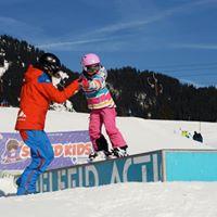 Snowboard instructor helps over the obstacle at the Alpine and Winter Sports School TOP ON SNOW Sudelfeld