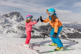 A girl and her instructor during private ski lessons for kids of all ages with ski school Thommi Nassfeld.